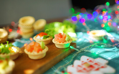 christmas tarts with red fish and lights on background 