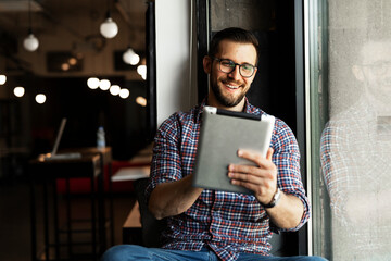 Young businessman using digital tablet in the office. Handsome man having video call