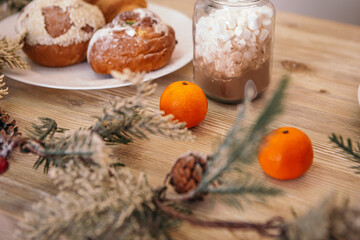Christmas beautiful decorated kitchen interior New Year wooden table utensils green tree branch products tangerines, copy space, bakery marshmallows