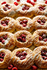 Yeast sweet buns with raspberries and white chocolate, close up view. Delicious homemade dessert