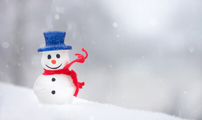 Naklejka na ściany i meble Snowman with red scarf on white snow background. Winter holidays. Christmas time. Copy space. 