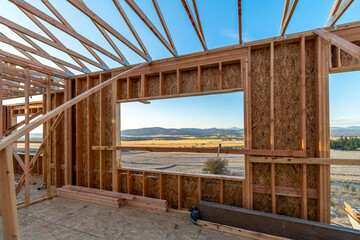 A new construction home being framed on a hillside with a view overlooking Spokane Valley and Liberty Lake, Washington, USA