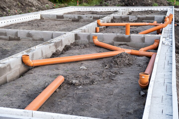 Ready Made cement foundation and Prepared Drainage System from Plastic pipes made by plumber in the ground during the building of a modular house in Europe. Construction Engineering concept
