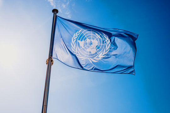 Valencia, Spain - September 8, 2021: UN flag waved against the sun and blue sky.