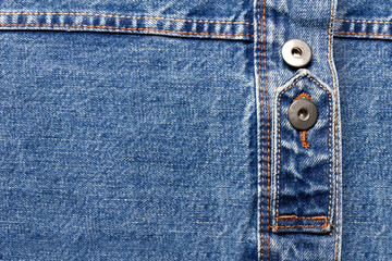 Texture backdrop photo of blue colored denim cloth with belt and buttons.