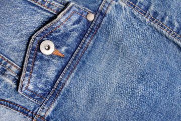 Texture backdrop photo of blue colored denim cloth with pocket and seams.