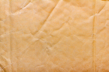 Texture backdrop photo of yellow colored crumbled packing paper surface.