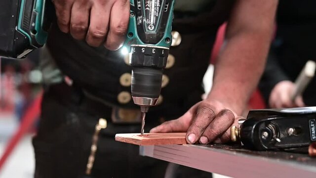 Carpenter drilling a hole in a piece of wood