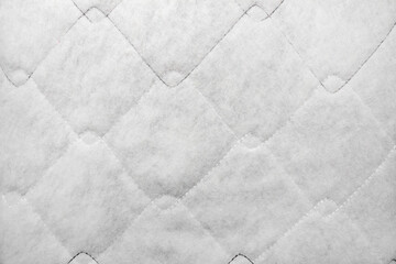 Texture backdrop photo of white colored sintepon material stitching pattern.