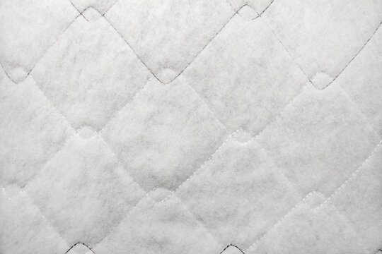 Texture backdrop photo of white colored sintepon material stitching pattern.