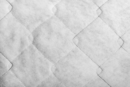 Texture backdrop photo of white colored sintepon material stitching pattern.