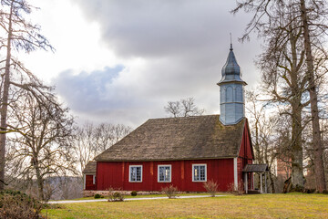 Fototapeta premium Beautiful view to Church Turaida Rose at the lake bank in autumn. Countryside landscape near a famous Latvian resort Sigulda, Latvia, Vidzeme Region, Picturesque places Turaida Museum Reserve, Europe