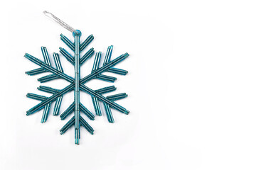 Cyan colored snowflake, Christmas ornament on white background with space for text, minimal concept