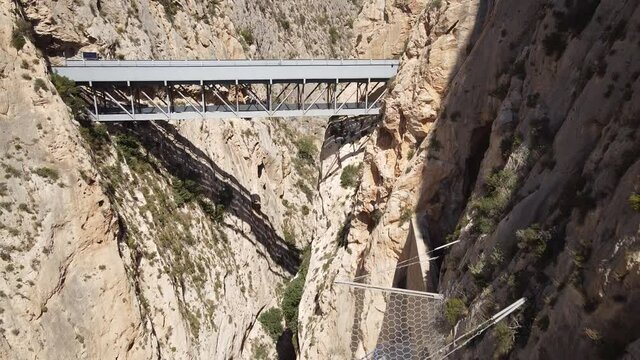 Vistas A&eacute;reas de puentes de carretera secundaria con curvas de paso de veh&iacute;culos y trenes por t&uacute;neles y puentes sobre un barranco.