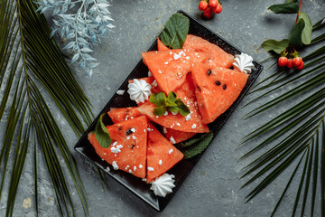 Pieces of fresh red watermelon on a black plate