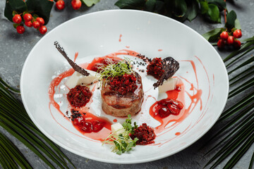 Appetizing beef in sweet sauce close up. Chopped beef meat in cherry sauce with vegetables on plate. Delicious european cuisine