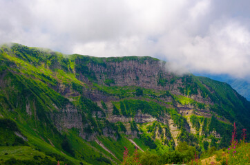 Fototapeta premium Mountain peaks in summer on a sunny day together with clouds