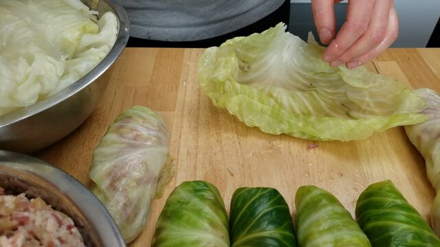 Home cooking - Close up of meat and rice stuffing being wrapped with cabbage leaf making rolls ready to be cooked.