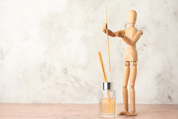 Wooden mannequin with aroma diffuser on light background