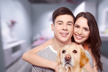 Love And Care Concept. Portrait of cheerful couple patting their dog