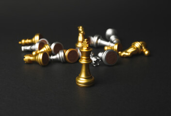 Golden king with chess pieces on dark background