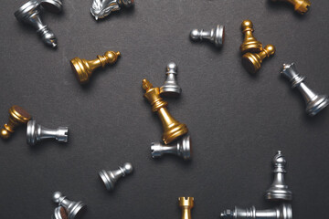 Scattered chess pieces on dark background