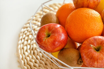 Basket with fresh fruits on light table, closeup