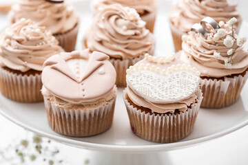 Dessert stand with tasty wedding cupcakes on table