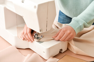 Woman sewing clothes at table, closeup