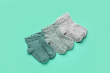 Different baby socks on color background