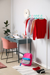 Stylish school uniform and backpack in interior of room