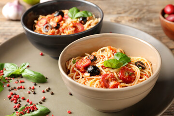 Bowls with tasty Pasta Puttanesca on table
