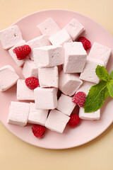 Plate with tasty sweet marshmallows, mint and strawberries on color background
