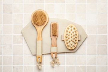 Board with different body brushes on light tile background