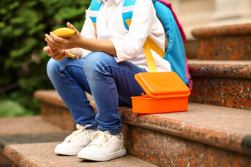 Cute little girl having school lunch outdoors