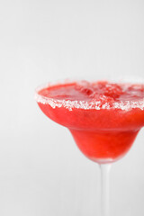 Glass of tasty strawberry margarita on white background