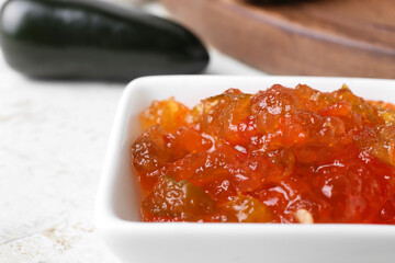 Bowl with delicious jalapeno pepper jam on table, closeup