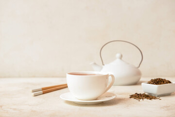 Obraz na płótnie Canvas Cup of tasty hojicha green tea on light background