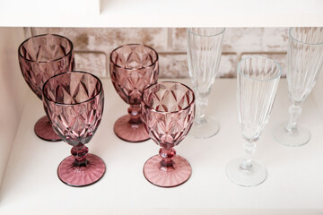 Empty stylish glasses on shelf in room