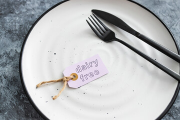 dairy-free product tag on top of dining plate with fork and knife, healthy nutrition and ethical choices