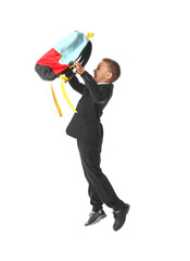 Jumping little schoolboy on white background