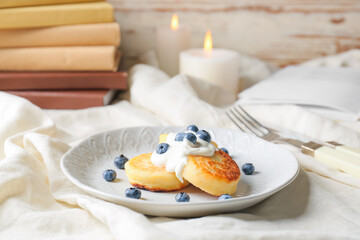Plate with cottage cheese pancakes and blueberry on table, closeup