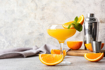 Glass of orange margarita cocktail on light background