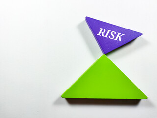 Business concept.Text RISK writing on colored tangram on a white background.