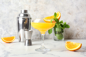 Fototapeta premium Glass of orange margarita cocktail on light background