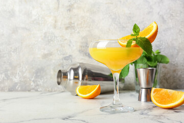 Glass of orange margarita cocktail on light background