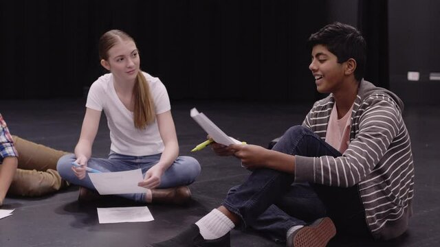 Junior High Students And Teacher Rehearsing Script On Theater Stage