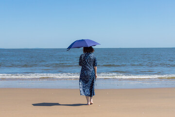 夏の海のビーチで散歩している女性の姿