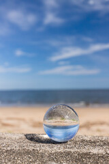 Fototapeta na wymiar 真夏の海の海岸で水晶ガラスボールを撮影した風景