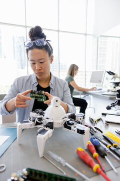 Female engineer with semiconductor assembling robotics